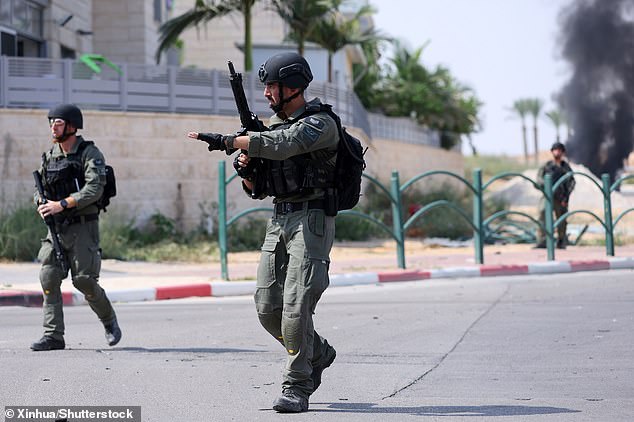 It follows Hamas attacks on October 7 in response to the ongoing occupation of Palestinian land, with the onslaught killing around 1,200 Israeli people and over 250 being taken hostage. Pictured: IDF soldiers in the Israeli town of Ofakim on October 8 2023
