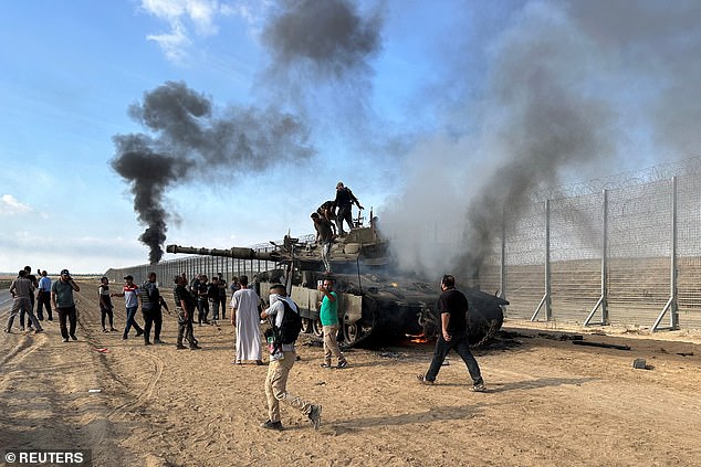 In 2024, there were 3,528 anti-Semitic incidents in the UK, the second-highest total ever recorded, a shocking new report reveals today. Pictured: Palestinians stand atop of a Israeli military vehicle after breaking down a border fence in Gaza on October 7 2023