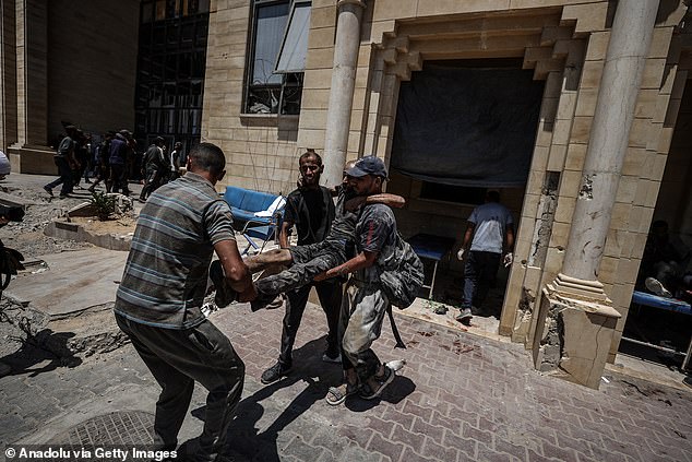 An injured Palestinian is being transported to hospital after the shooting near the aid trucks