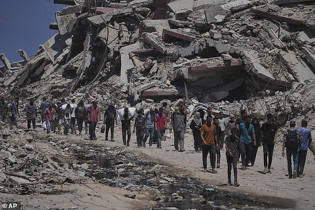 Palestinians carry sacks of humanitarian aid unloaded from trucks convoy that had been heading to Gaza City on Sunday, July 20