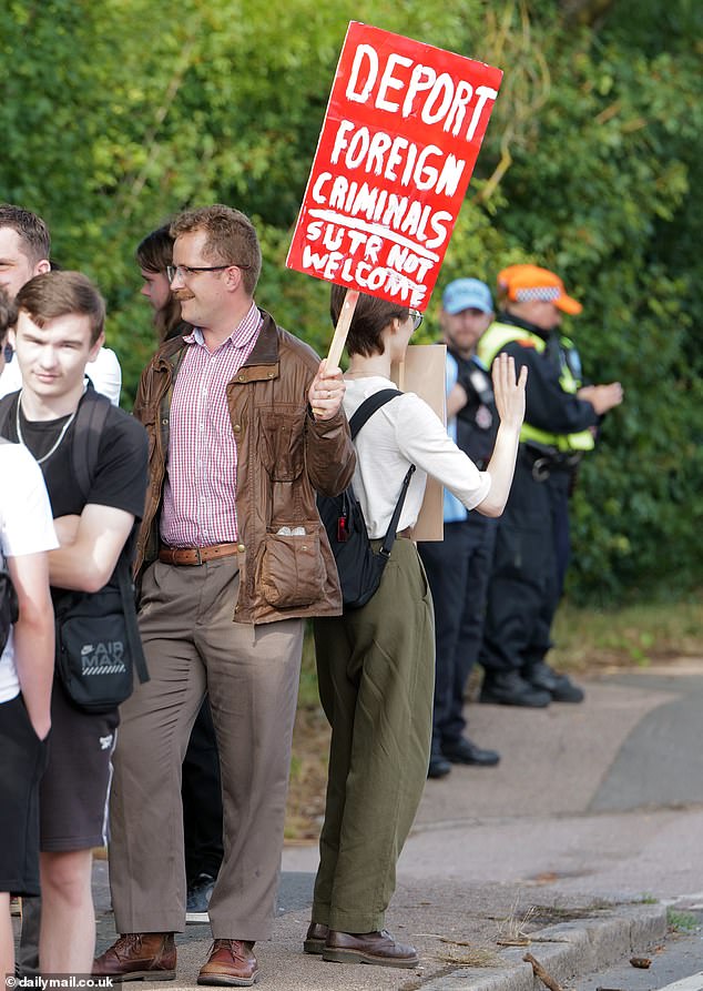 A man holds a sign this evening which reads 'Deport Foreign Criminals' outside The Bell Hotel