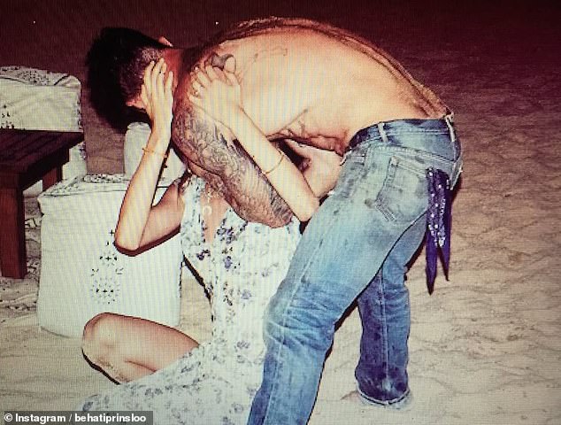 Another photo was taken as Levine gave his wife a kiss as they spent time on the sandy shore of a beach