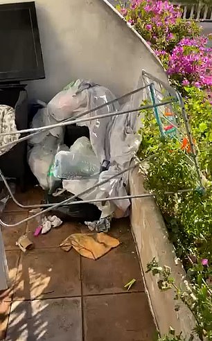 Rubbish is left strewn across the garden of Ian and Emma Williams after the squatters leave the property
