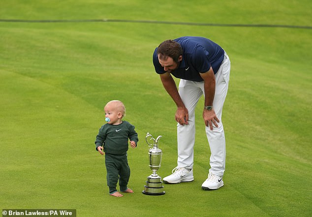 After his victorious dad scooped him up, Bennett took the time to examine the Claret Jug