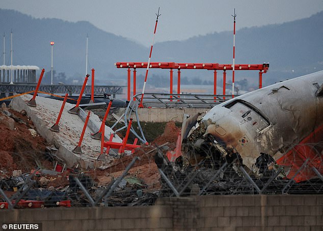 The wreckage of the Jeju Air aircraft that went off the runway and crashed at Muan International Airport lies near a concrete structure it crashed into, in Muan, South Korea, December 30, 2024