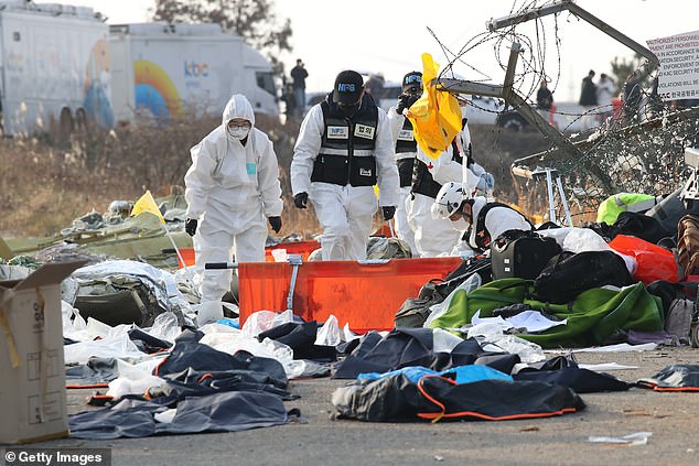 South Korean rescue team members check near the wreckage of a passenger plane at Muan International Airport on December 29, 2024 in Muan-gun, South Korea