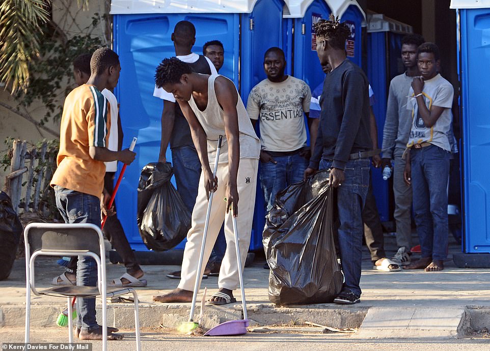 At Heraklion, the Crete island's capital, 270 migrants are guarded in a port building as they wait for a ferry to Athens