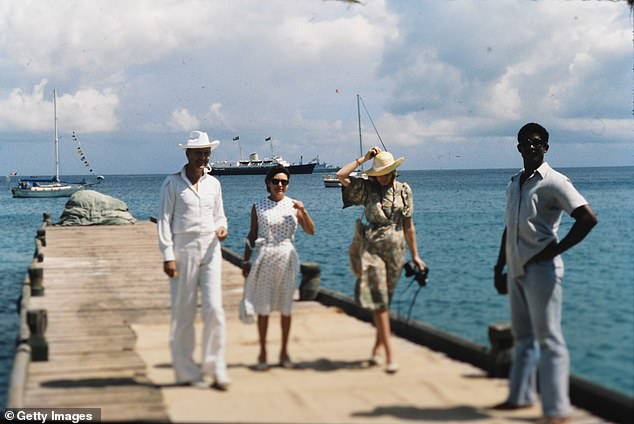 Princess Margaret, Colin Tennant, Lord Glenconner and Anne Tennant, Lady Glenconner wait on the jetty for Queen Elizabeth ll and Prince Philip's arrival to Mustique in 1977