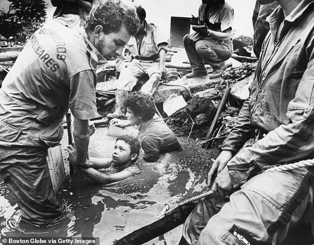 Pictured: Emergency workers attempt to rescue Omayra after she was trapped in debris and lahar from the eruption