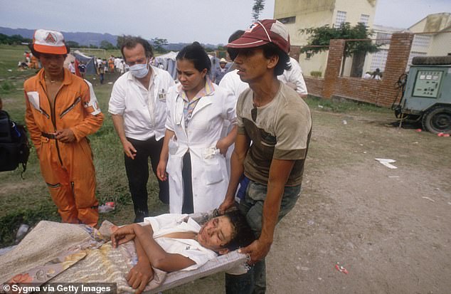 Rescue workers carry an injured person, caught in a lahar flowing from the erupting Nevado del Ruiz volcano in Colombia, on a stretcher