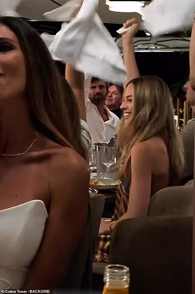 Rocking a glowy tan that she no doubt caught while sunbathing under the Italian rays, Margot looked radiant as ever as she enjoyed the lively dinner