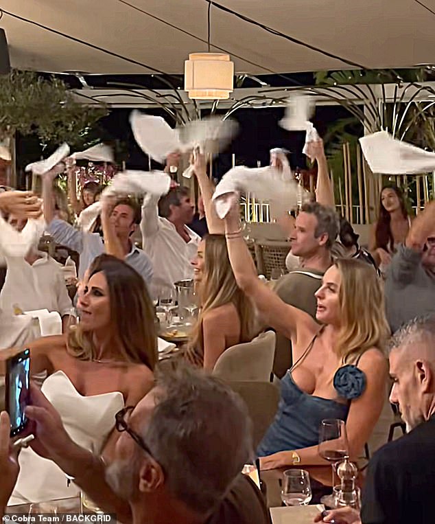 The Australian beauty was all smiles as she and her fellow dinner guests held their napkins in the air and spun them around, an Italian custom often demonstrated during celebrations