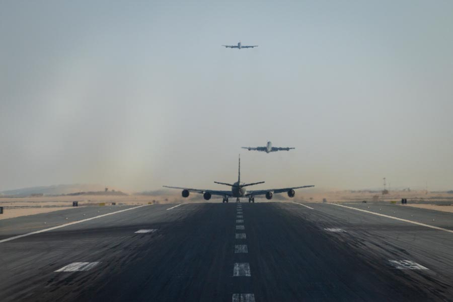 Three military aircraft on a runway.