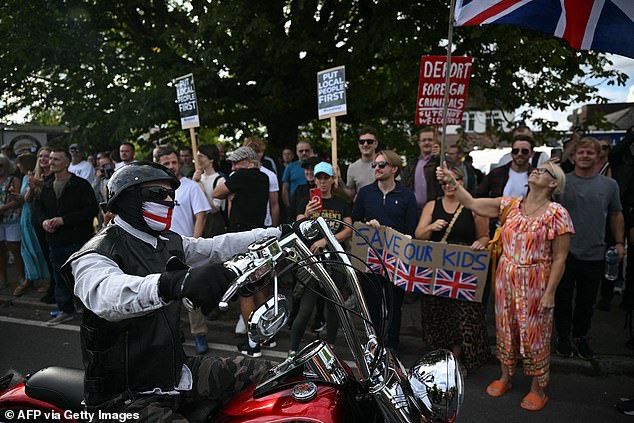 A man with a St George's flag mask rode past the protesters who lined the pavements holding flags and signs