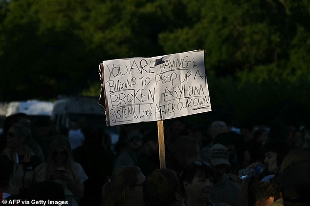 A sign held up among the crowds read: 'You are paying billions to prop up a broken asylum system. Look after our own'