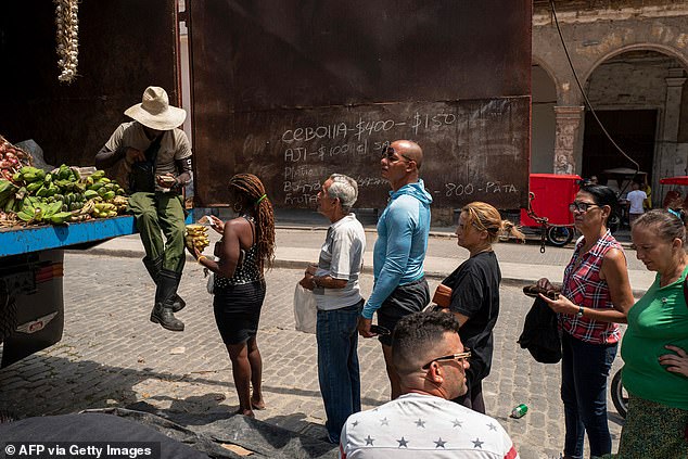 People queue up for food in Cuba where the average monthly wage is stuck at just $16.50
