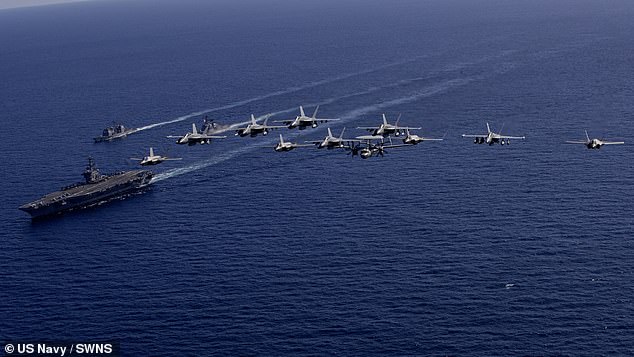 Jaw-dropping images capture the moment the U.S. Navy aircraft, attached to a Carrier Air Wing (CVW) 5, was joined by Britain's vast £3.5billion vessel, while U.S. warplanes also roared overhead