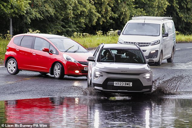 Drivers navigate through a flooded road in an underpass on Blacks Road in Belfast yesterday
