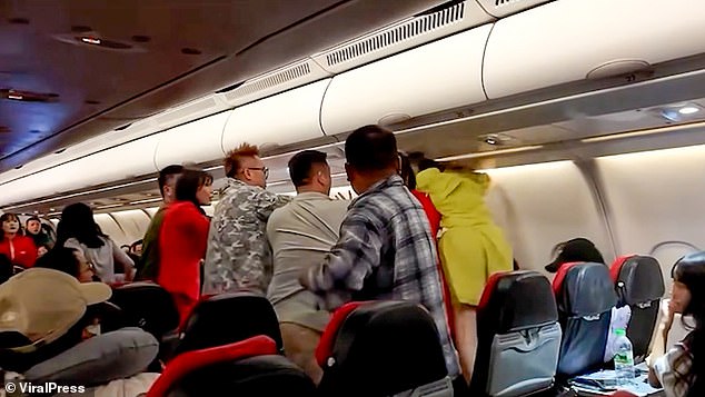 Video shows a woman in a green outfit and baseball cap leaning across the seat while repeatedly throwing punches at the man