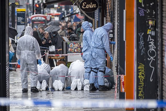 Forensic officers conducting a search outside the restaurant following the shooting
