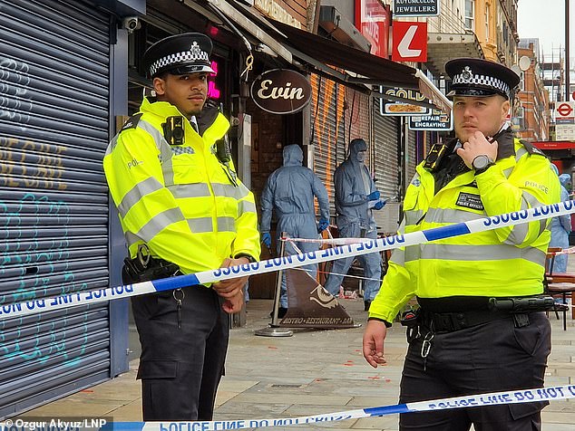 Police stand guard outside the scene of the shooting