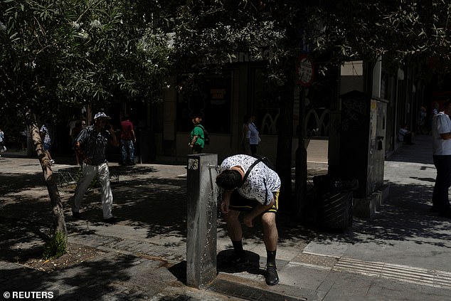 A person drinks water from a drinking fountain, during a heatwave in Athens, Greece, July 22, 2025
