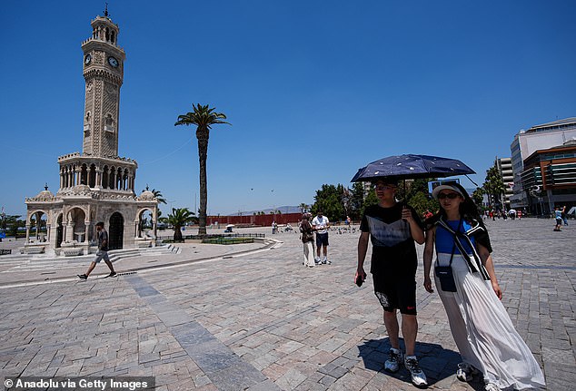 People use umbrellas to shield from the sun as temperatures rise up to 40 degrees Celcius in Izmir, Turkiye on July 21, 2025