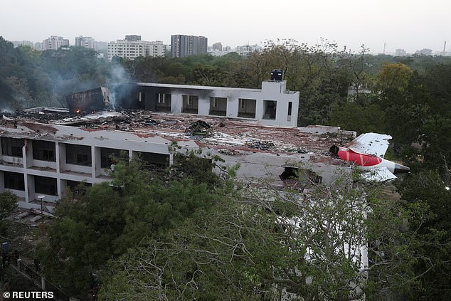 Pictured: The Air India flight 171 stuck on the side of the building after the crash