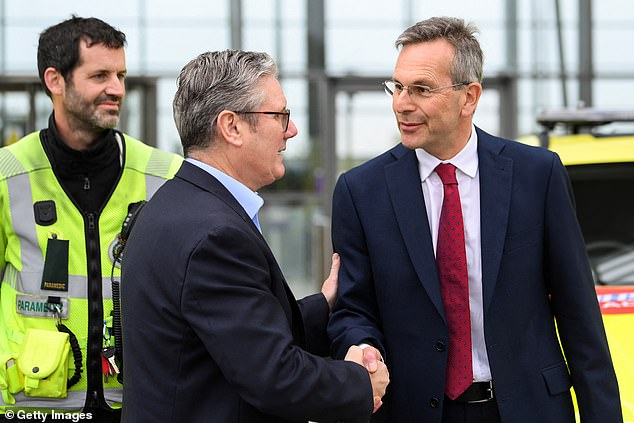 Daniel Elkeles, chief executive of NHS Providers (right), shakes hands with prime minister Sir Keir Starmer (centre)