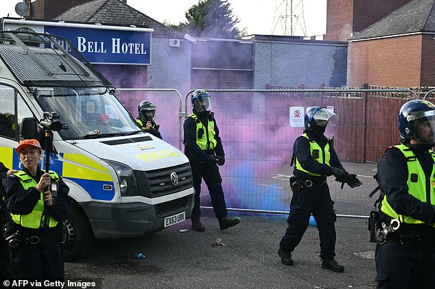 Bottles and smoke flares were thrown towards police vehicles stationed outside The Bell Hotel