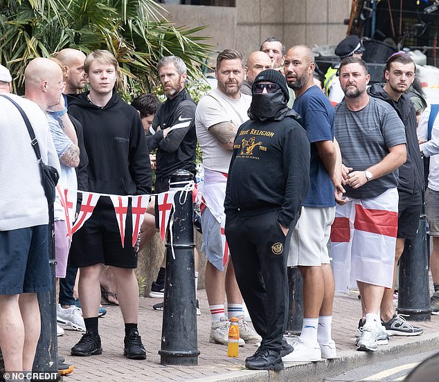 Protesters gathered outside the hotel, some wearing masks and others draped in St George's flags