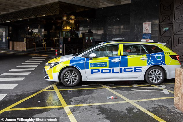 A police officer sits in a car outside the entrance of the Britannia Hotel in Canary Wharf