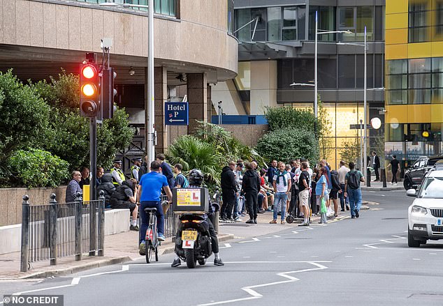 Dozens of protesters gather outside the Britannia International Hotel in Canary Wharf on Tuesday