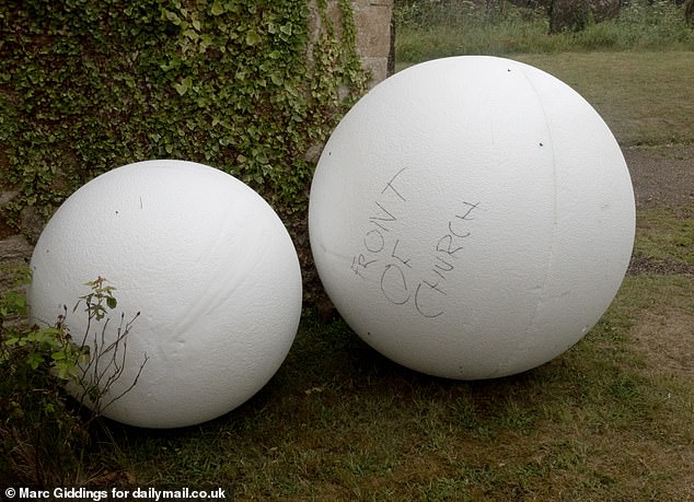 Giant floral balls made up of water-absorbing foam specifically designed for use in floral arrangements could be seen lined up around the church grounds where 300 people will attend
