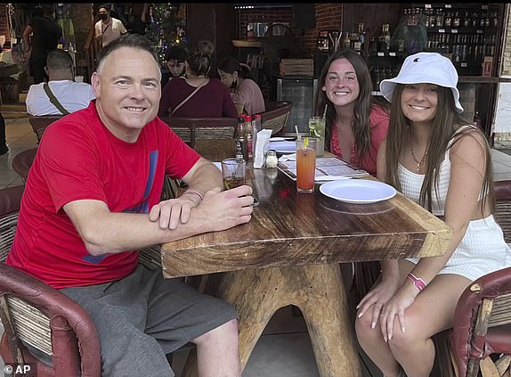 This Dec. 2021 photo provided by Jazzmin Kernodle shows father Jeff Kernodle, left, Xana, middle, and Jazzmin, in Puerto Vallarta, Mexico. (Courtesy of Jazzmin Kernodle via AP)
