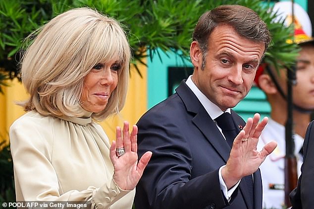 France's President Emmanuel Macron and his wife Brigitte Macron wave at the Presidential Palace in Hanoi on May 26, 2025