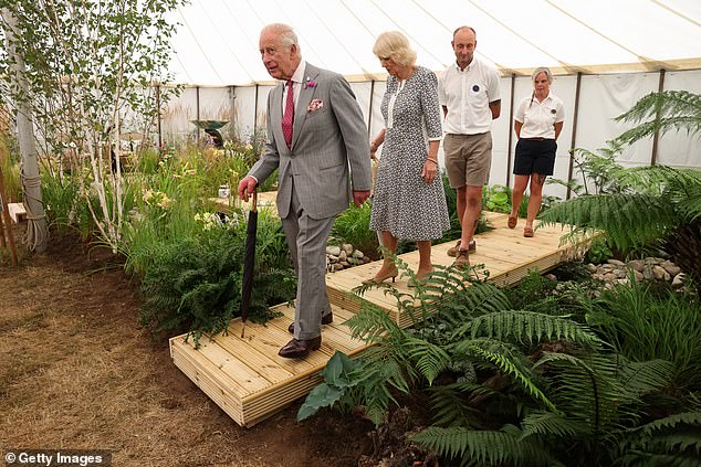 The couple walked up and down one of the tents, examining the fruits, vegetables and flowers on display