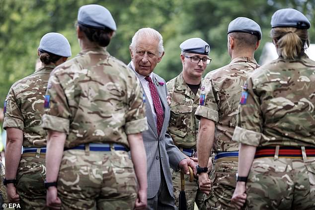 Britain's King Charles III (C) meets members of the British Armed Forces