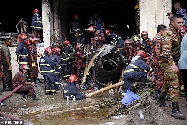 Firefighters work to remove the wreckage from a building, after an air force training aircraft crashed into Milestone College campus, in Dhaka, Bangladesh, July 21, 2025