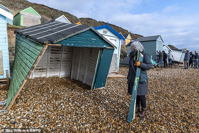 Pictured: Jeannie Medd beside her damaged beach hut