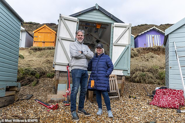 Pictured: James and Helena Cox beside their beach hut