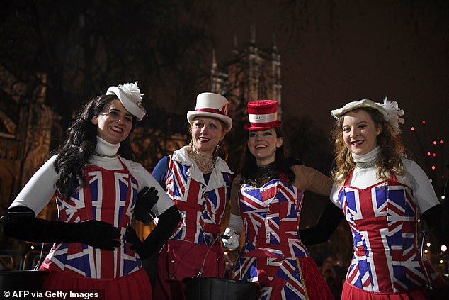 Brexit supporters dressed in Union flag-themed clothes, pose for a photograph as they wait for the festivities to begin in Parliament Square, the venue for the Leave Means Leave Brexit Celebration in central London on January 31, 2020, the day that the UK formally leaves the European Union