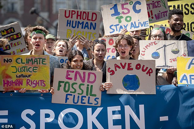 Climate activists and campaigners demonstrate outside the International Court of Justice