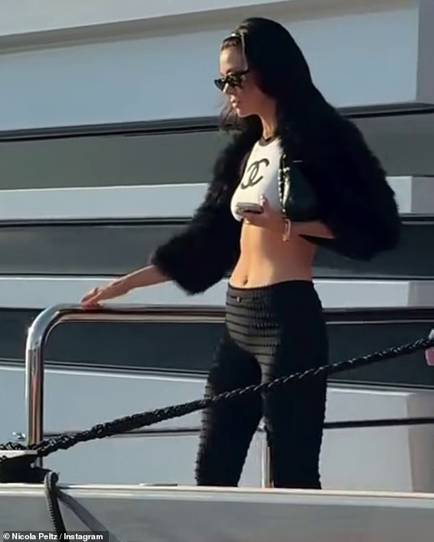 The heiress showcased her jaw-dropping figure as she headed ashore and turned heads in a Chanel crop top which she teamed with a fluffy shrug, despite the scorching weather