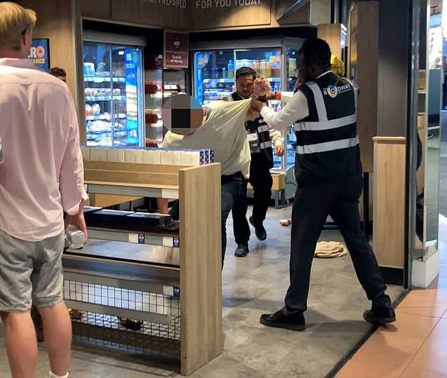 Fightback: Security guards eject a thief from a Greggs in Hammersmith, West London