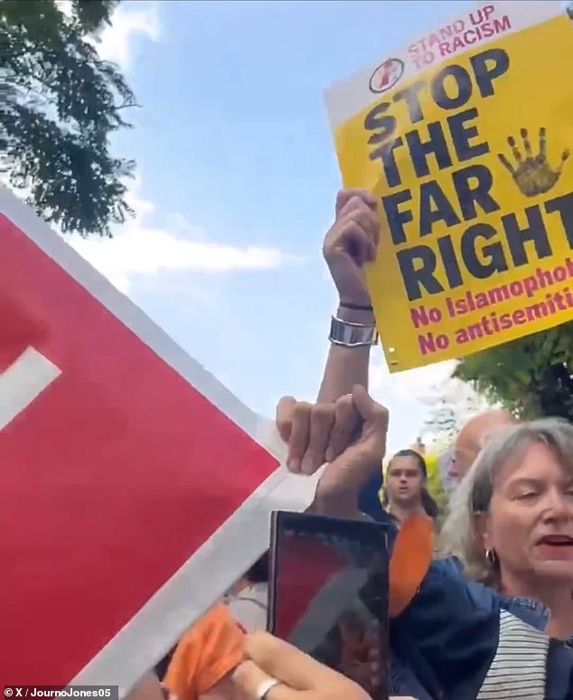 Counter-protesters gathered next to a 'stop the boat' banner holding posters up which said 'stop the far right'