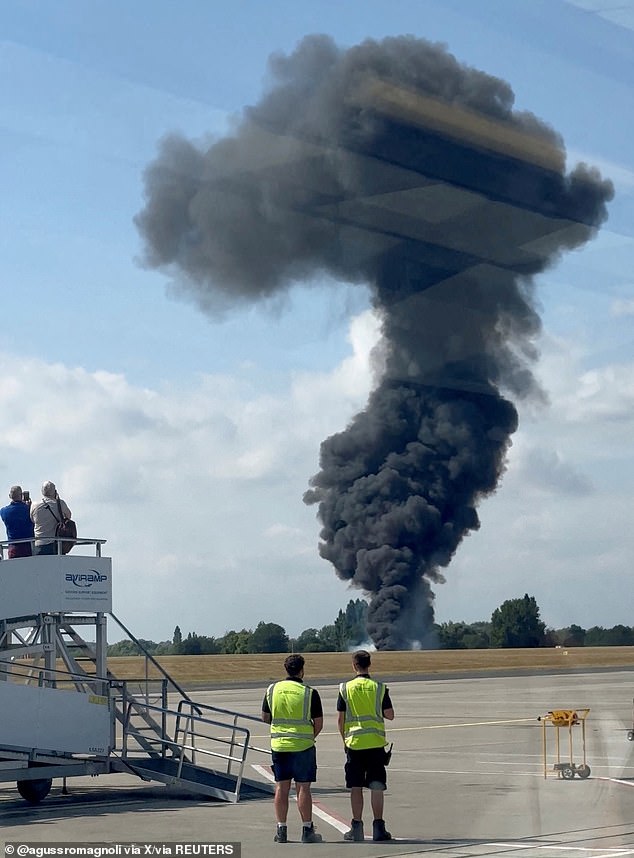 A plume of black smoke rises from an area near the runway after the plane crash on July 13