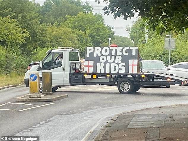 A van driven by protestors, sporting a giant sign reading 'Protect our kids'