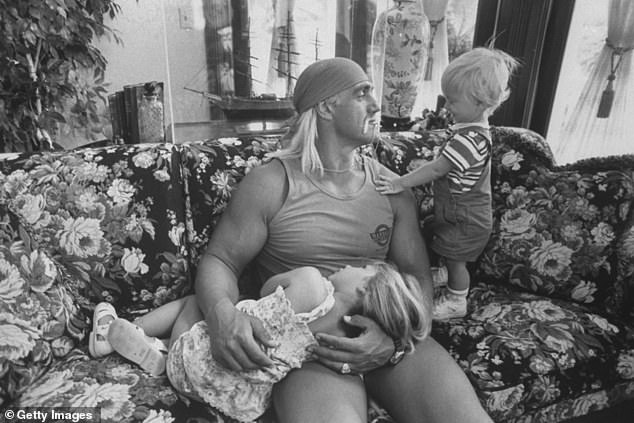 A younger Hogan is seen with his children Brooke, 3, and Nick, 1, on a floral-print couch