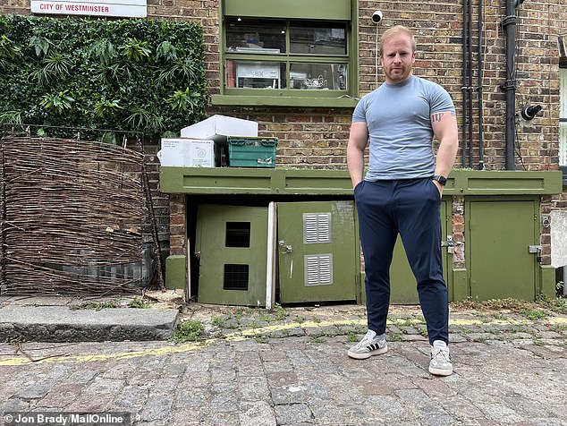Mr Wilkins standing beside one of the padlocked cupboards he asks delivery drivers to use when dropping off supplies - which has been kicked in by a prospective thief